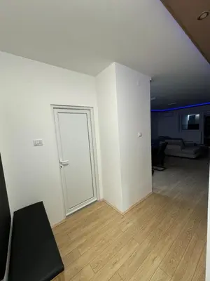 an empty room with a door and a wooden floor at Brasic Apartman in Zaječar