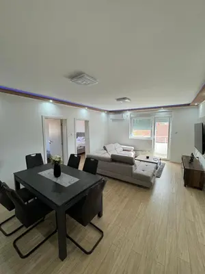 a living room with a table and a couch at Brasic Apartman in Zaječar