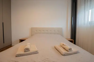 a bedroom with a bed with two towels on it at NOVA Apartmani in Kraljevo
