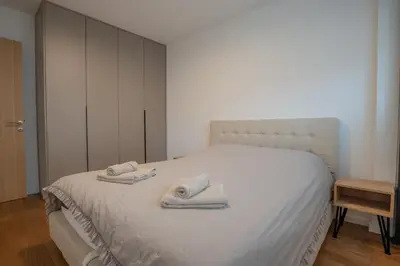 a bedroom with a white bed with towels on it at NOVA Apartmani in Kraljevo