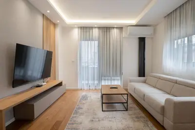 a living room with a couch and a flat screen tv at NOVA Apartmani in Kraljevo