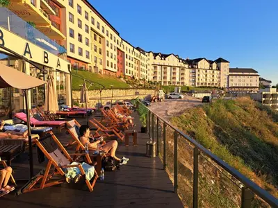 a group of people sitting in chairs on a boardwalk at Mips Amadeus P85 in Cajetina