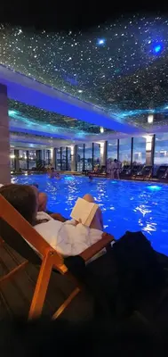 a hotel with a swimming pool with people laying in chairs at Mips Amadeus P85 in Cajetina