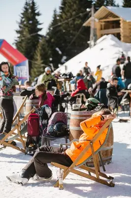 a person sitting on a chair in the snow at Rtanj Kopaonik Eco Resort & Spa in Kopaonik