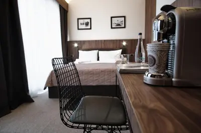 a bedroom with a bed and a desk with a chair at Rtanj Kopaonik Eco Resort & Spa in Kopaonik