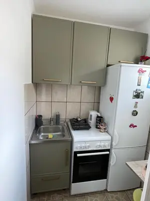 a small kitchen with a stove and a refrigerator at VERA apartman in Zaječar