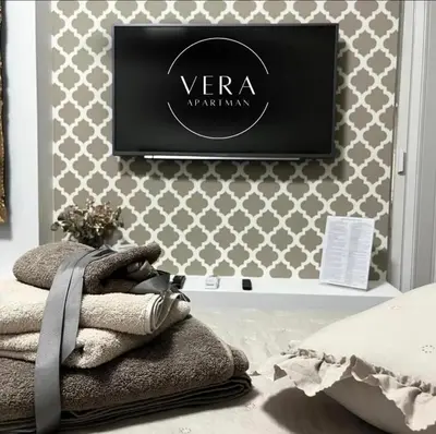 a tv on a wall in a room with towels at VERA apartman in Zaječar