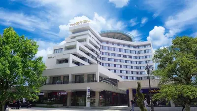 a hotel building with people walking in front of it at Zepterme Apartman 605 Premium in Vrnjačka Banja