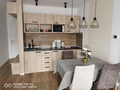 a kitchen with a table and a microwave at Bela Idila - Kopaonik in Kopaonik