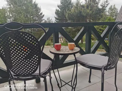 two chairs and a table with two cups on a balcony at Bela Idila - Kopaonik in Kopaonik