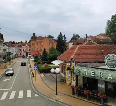 a street in a town with cars driving down a street at Vrnjačka Banja - Apartman Zen in Vrnjačka Banja
