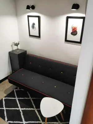 a black couch in a room with a white wall at Vrnjačka Banja - Apartman Zen in Vrnjačka Banja