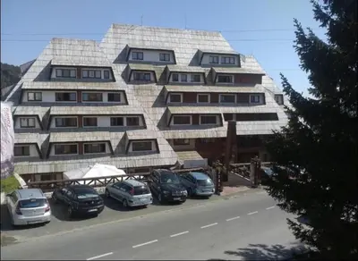 a large building with cars parked in front of it at Apartment 111 at Zoned Apart Hotel & Spa - Apartman 111 u hotelu Zoned in Kopaonik