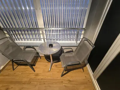 a balcony with a table and chairs and a window at Floid in Niš
