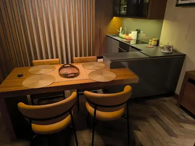 a kitchen with a wooden table and some chairs at Floid in Niš