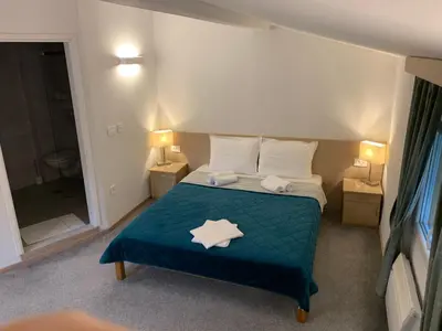 a bedroom with a bed with a blue comforter at Garni hotel Vir in Vrnjačka Banja