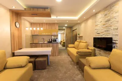 a living room with couches and a table and a kitchen at Apartments Andrejic in Kopaonik