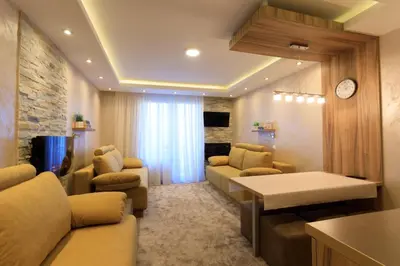 a living room with couches and a clock on a wall at Apartments Andrejic in Kopaonik
