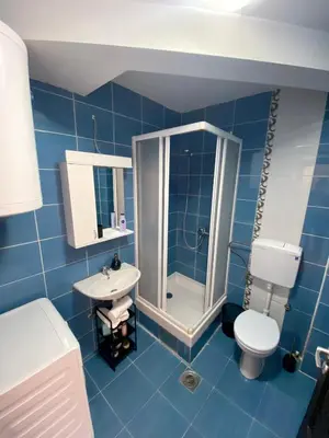 a blue bathroom with a toilet and a sink at City view & pool apartment 2 in Niš