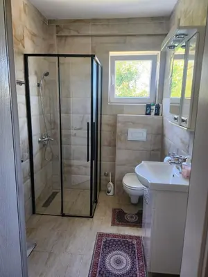 a bathroom with a shower and a toilet and a sink at Apartman Goca in Vrnjačka Banja