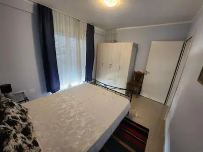 a bedroom with a white bed and a window at Apartman Goca in Vrnjačka Banja