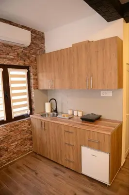 a kitchen with wooden cabinets and a sink at ThEOS in Vranje