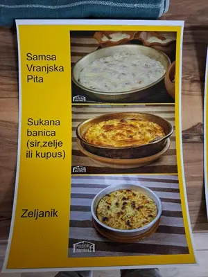 a yellow sign with three different types of pizza at ThEOS in Vranje