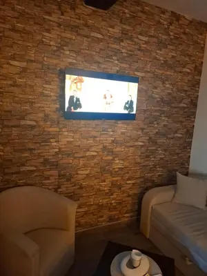 a living room with a tv on a brick wall at ThEOS in Vranje