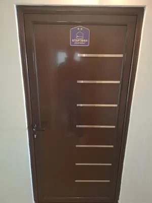 a brown door with a purple sign on it at ThEOS in Vranje