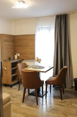 a dining room with a table and chairs and a window at Soko IN Spa in Soko Banja