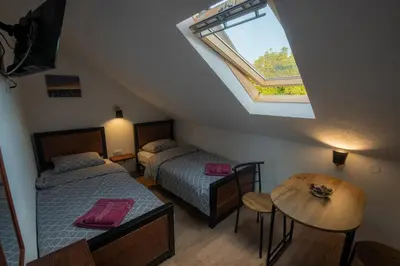 a attic bedroom with two beds and a window at Pansion Nana in Aleksandrovac