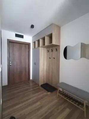 a living room with a bench and a wooden floor at Apartman TRAMONTO Kopaonik in Kopaonik