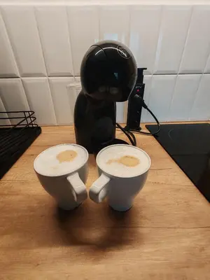 a coffee pot and two cups on a table at Apartman TRAMONTO Kopaonik in Kopaonik