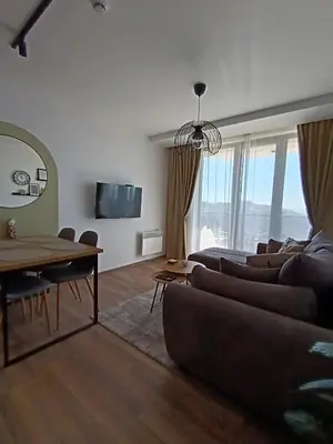 a living room with a couch and a table at Apartman TRAMONTO Kopaonik in Kopaonik