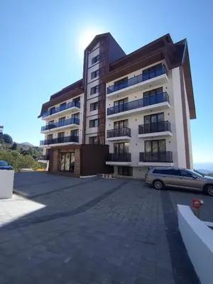 a building with a car parked in front of it at Apartman TRAMONTO Kopaonik in Kopaonik