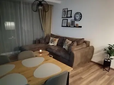 a living room with a couch and a table at Apartman TRAMONTO Kopaonik in Kopaonik