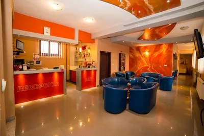 a restaurant with blue chairs in a room with orange walls at B&B Vila Tamaris in Zaječar