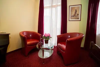 a waiting room with two chairs and a table with flowers at B&B Vila Tamaris in Zaječar