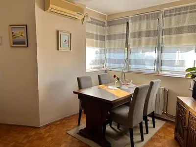 a dining room with a wooden table and chairs at Apartman NANA in Ćuprija