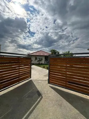 a pair of wooden gates in front of a house at Slatinska idila - kuća sa bazenom in Bunar