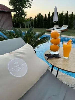 a table with two glasses of orange juice on it at Slatinska idila - kuća sa bazenom in Bunar