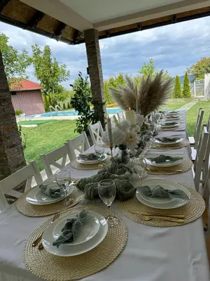 a long table with plates and wine glasses on it at Slatinska idila - kuća sa bazenom in Bunar