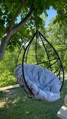 a bed hanging from a tree in the grass at Slatinska idila - kuća sa bazenom in Bunar