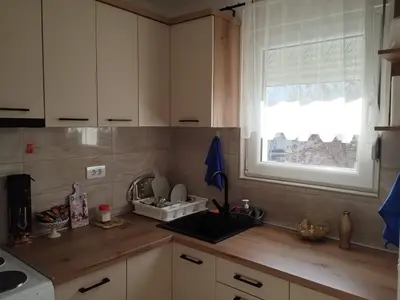 a kitchen with white cabinets and a window at NinaRelax in Soko Banja