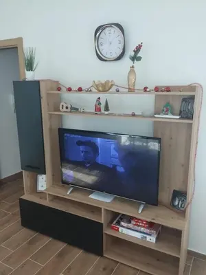 a television in a wooden entertainment center with a clock at NinaRelax in Soko Banja
