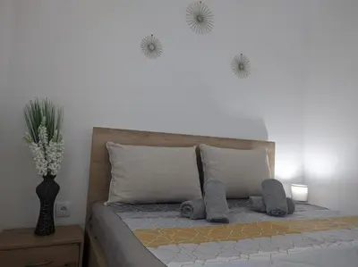 a bedroom with a bed with a vase of flowers on the wall at SokoSTAR Apartman in Soko Banja