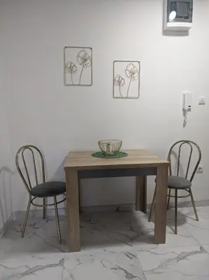 a wooden table with two chairs and a bowl on it at SokoSTAR Apartman in Soko Banja