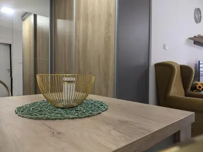 a wooden table with a gold bowl on top of it at SokoSTAR Apartman in Soko Banja