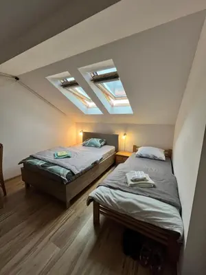 two beds in a room with two skylights at Apartman Nestoria Sokobanja in Soko Banja