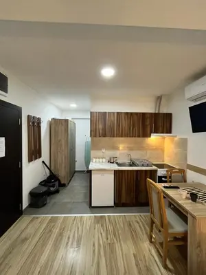 a kitchen with wooden cabinets and a table in a room at Apartman Nestoria Sokobanja in Soko Banja